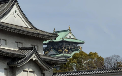 Osaka Castle rooftops against a clear blue sky